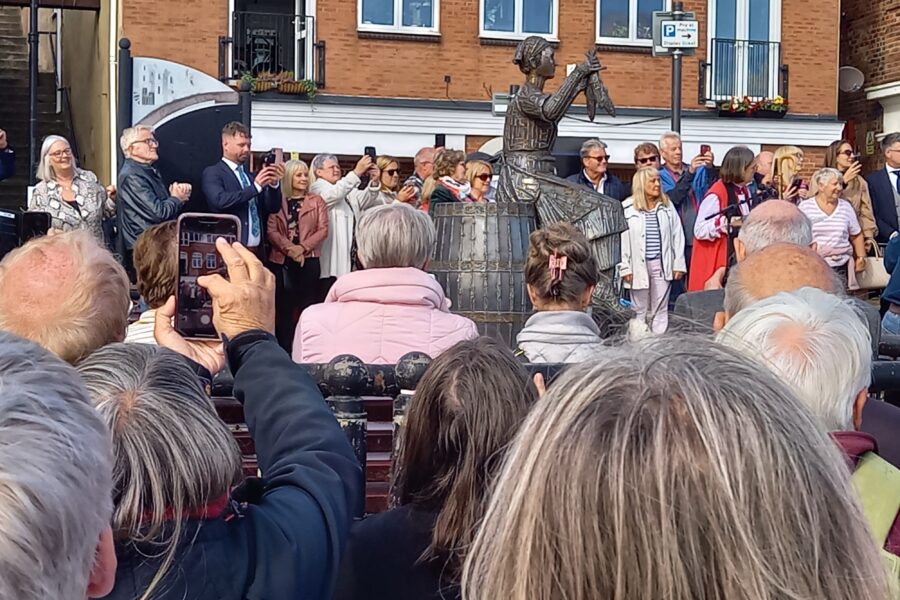 Photo of The Herring Girl statue with onlookers