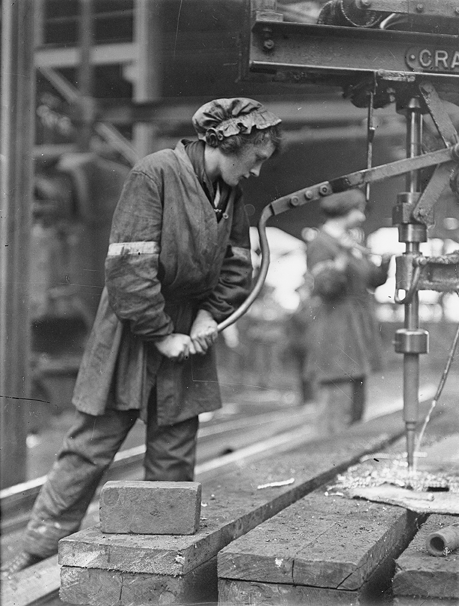 A female shipyard worker operating a magazine drilling plate.