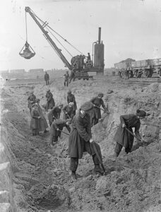 Female shipyard workers excavating a wet basin during WWI.