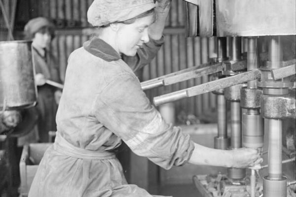 Image IWM (Q 20090) Photo of a woman worker operating a bolt tapping machine