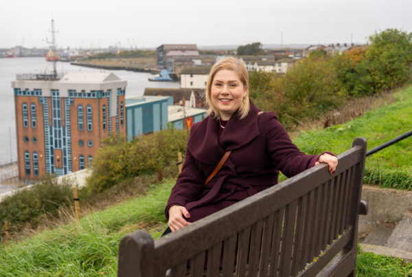Photo of Liz at the bench where she and her husband have enjoyed sitting since they first moved to North Shields