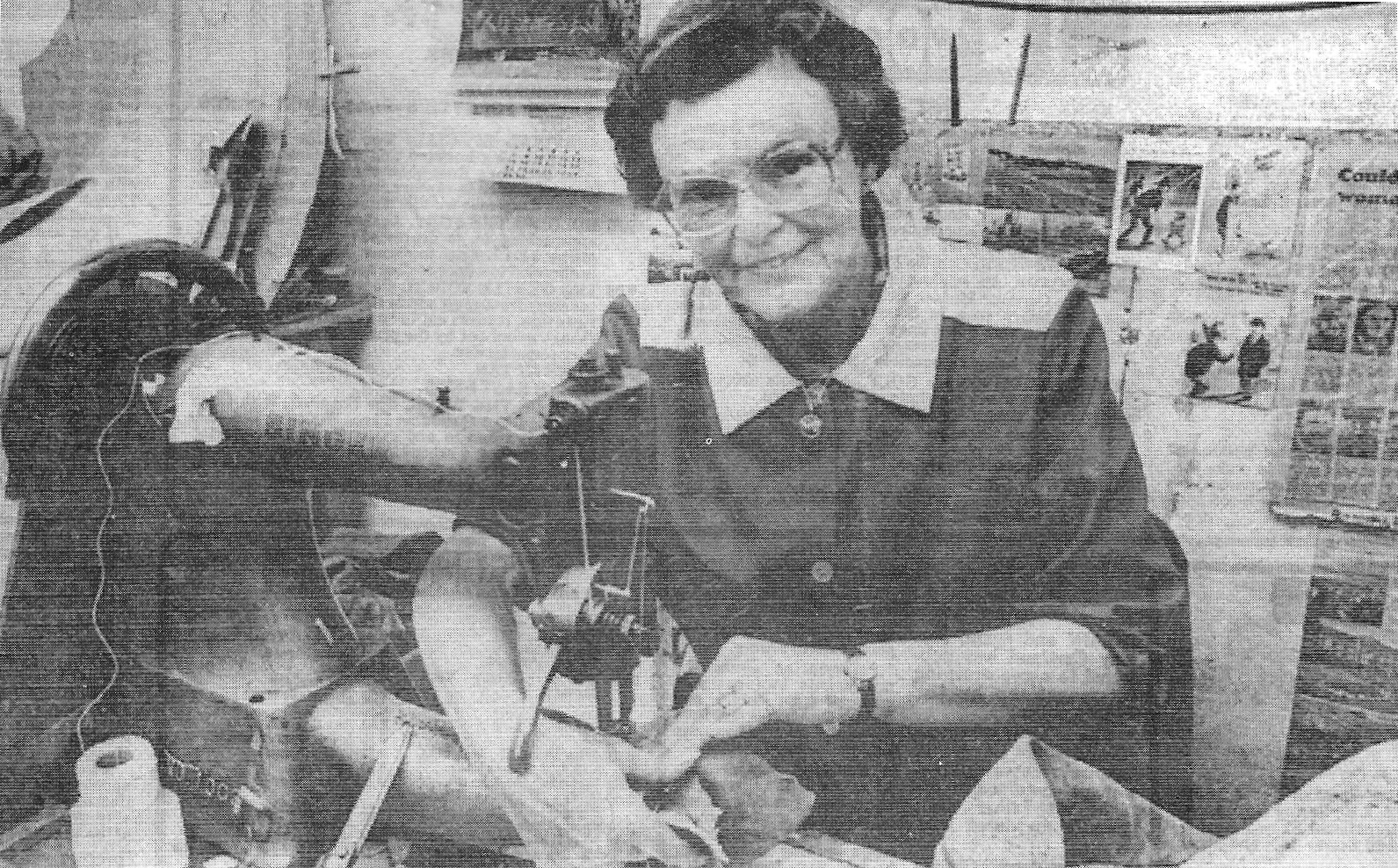 Newspaper photo of Lily Groves working at her sewing machine at Swam Hunters.